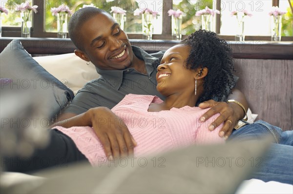 Young African couple looking at each other and smiling