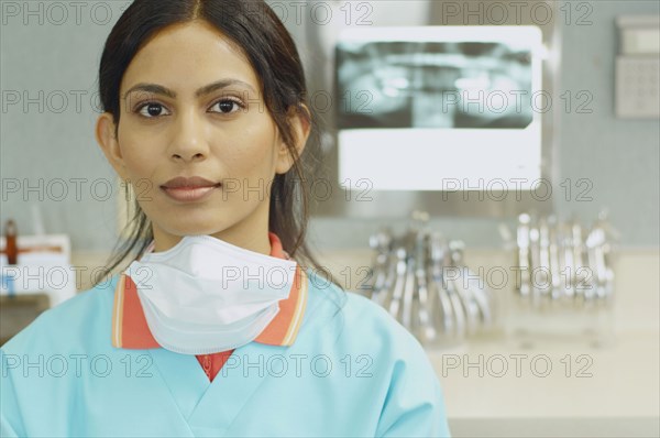 Indian female dental assistant next to x-rays