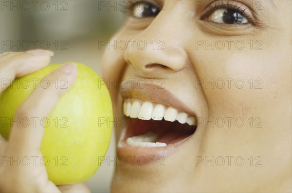 Close up of woman about to bite into an apple