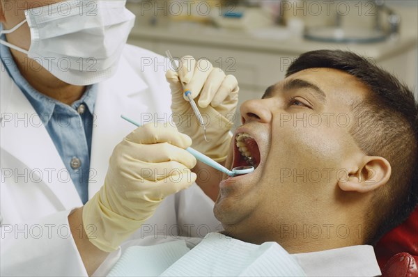 Dentist working on Indian man