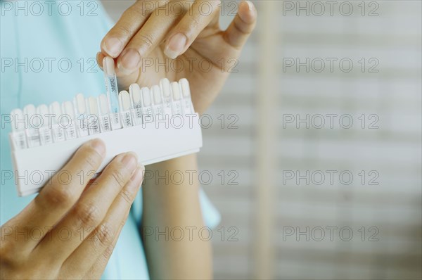 Close up of dentist holding tooth color samples