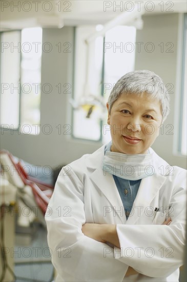 Senior Asian female dentist in office