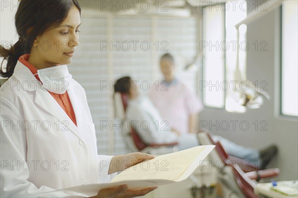 Indian female dentist looking at chart