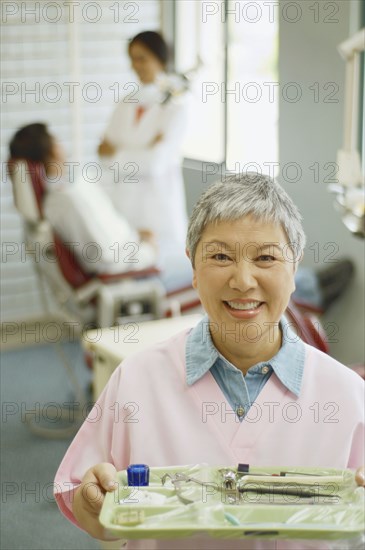 Senior Asian female dental assistant smiling