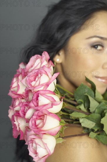 Hispanic woman holding bouquet of flowers