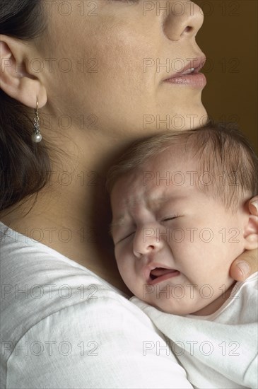 Hispanic mother hugging baby