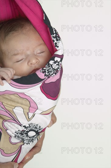 Hispanic baby sleeping in wrap