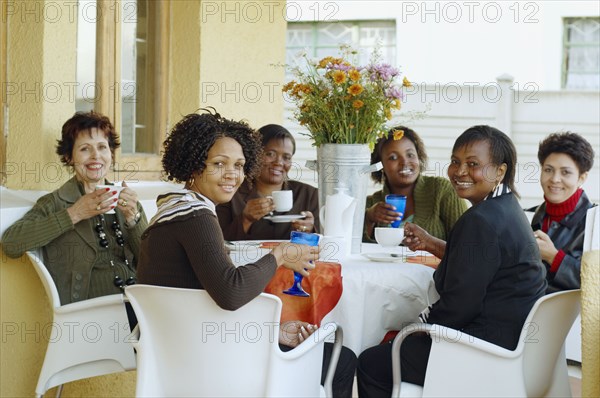 Multi-ethnic women having coffee outdoors