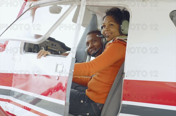 African couple in cockpit of airplane