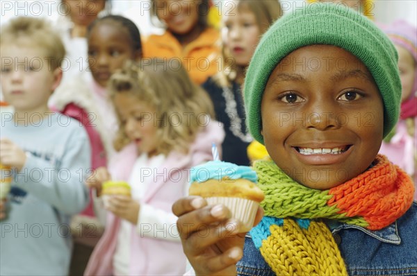 African girl holding cupcake