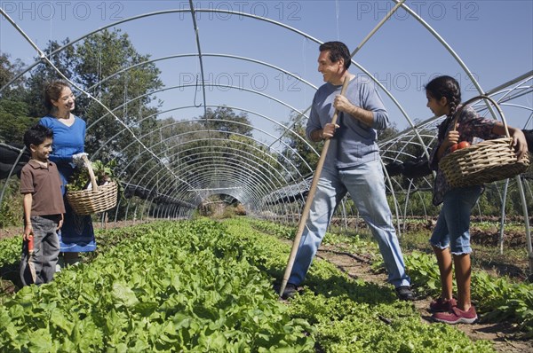 Multi-ethnic family harvesting organic produce