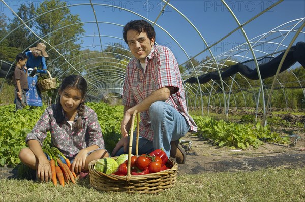 Multi-ethnic father and daughter with organic produce