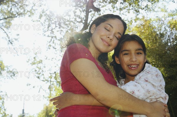 Hispanic mother and daughter hugging