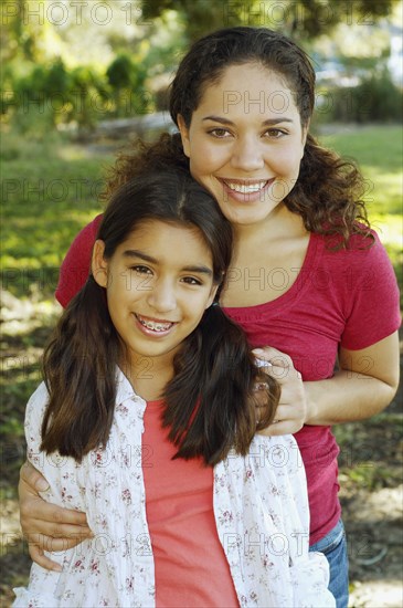 Hispanic mother and daughter hugging