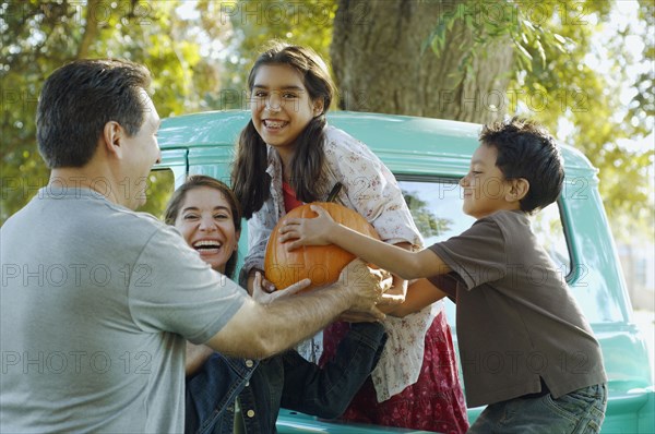 Multi-ethnic family holding pumpkin