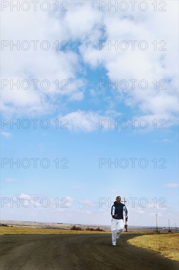 Mixed race man running on remote road