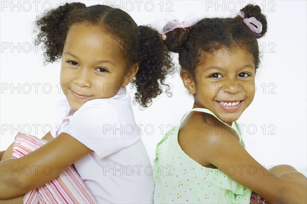 Multi-ethnic girls sitting back to back