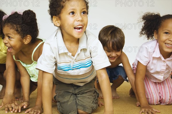 Multi-ethnic children kneeling and smiling