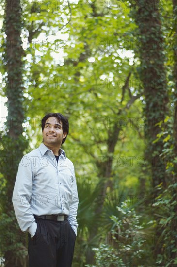 Hispanic businessman standing in woods