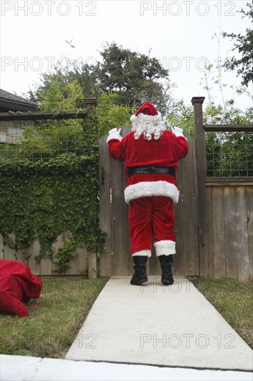 Santa peering over fence gate