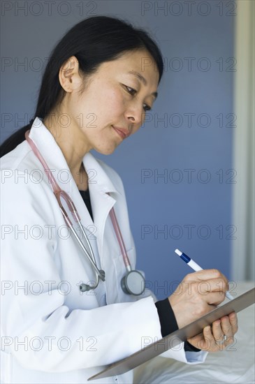 Japanese doctor writing on clipboard