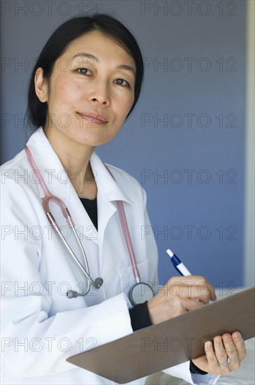 Japanese doctor writing on clipboard