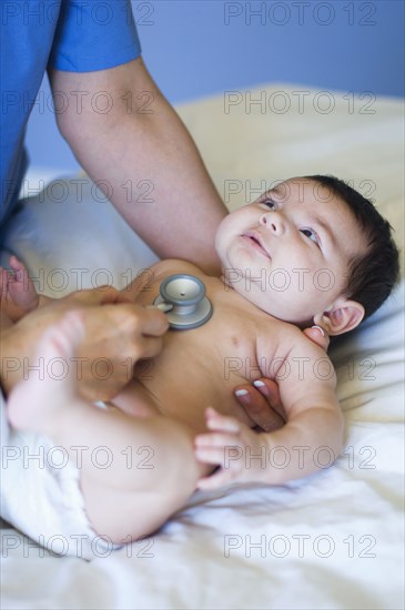 Nurse listening to baby's heartbeat in office