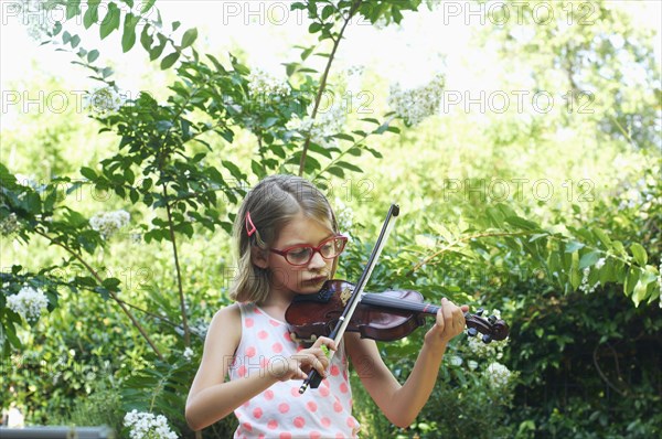 Hispanic girl playing violin outdoors