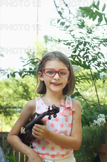 Hispanic girl holding violin outdoors