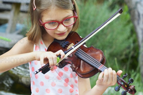 Hispanic girl playing violin outdoors