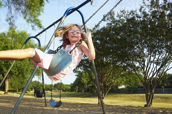 Hispanic playing on swings in park