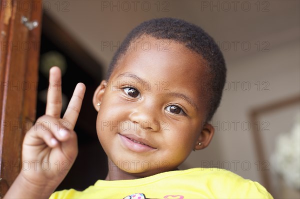 Mixed race girl giving peace sign