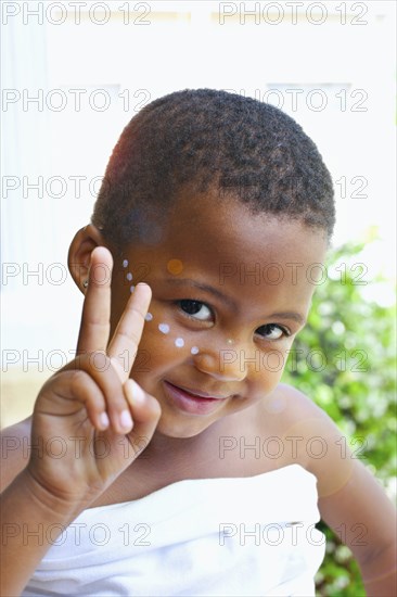 Mixed race girl giving peace sign