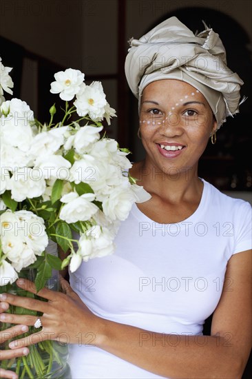 Mixed race woman holding bouquet of flowers