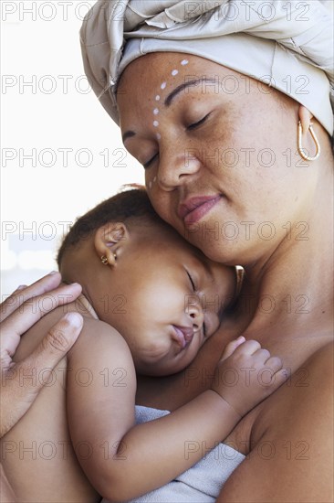 Mixed race mother cradling baby