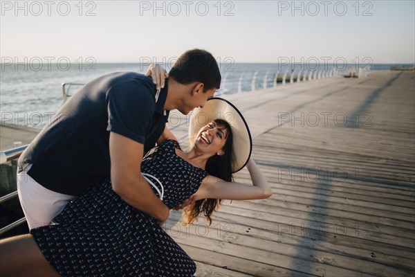 Caucasian man dipping woman at waterfront