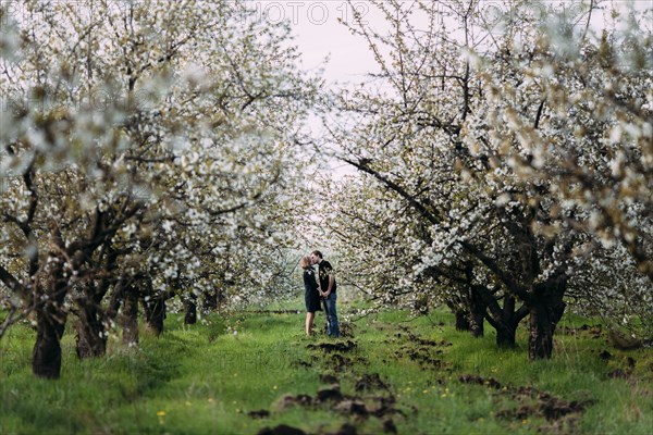 Caucasian couple kissing near trees