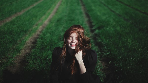 Smiling Caucasian woman in rows of grass