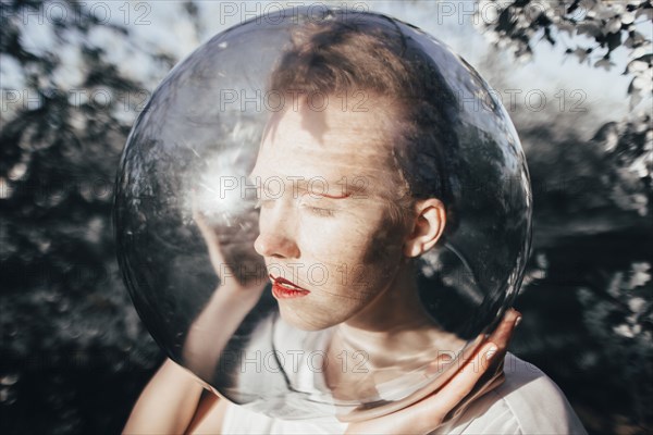 Unusual Caucasian teenage girl wearing glass helmet on head