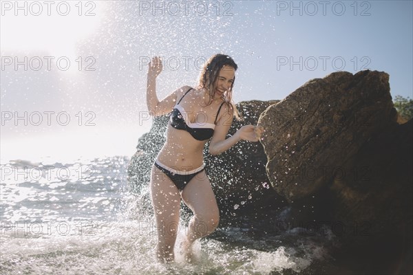 Caucasian woman splashing in ocean waves