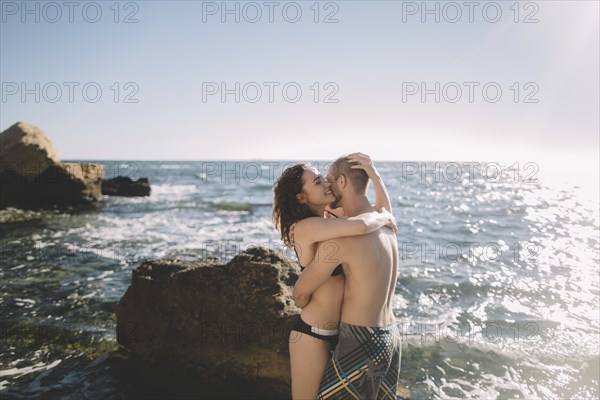 Caucasian couple hugging in ocean
