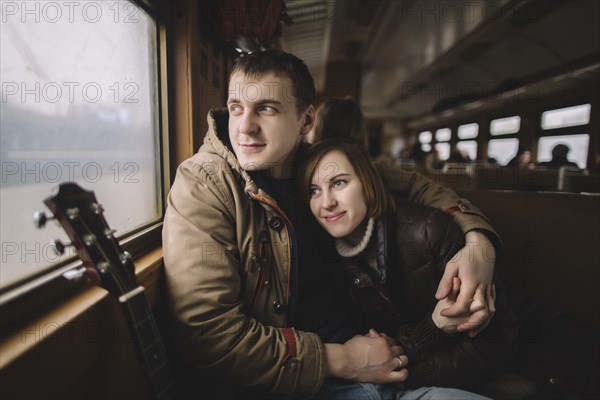 Caucasian couple hugging on train