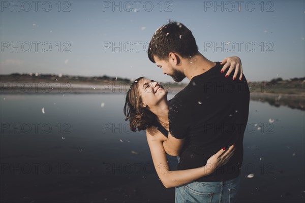 Caucasian couple hugging at lake