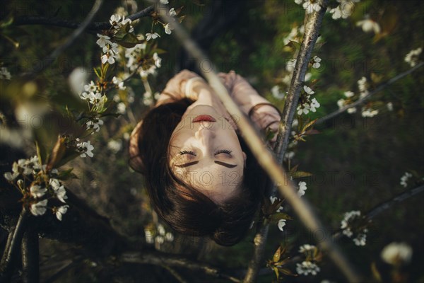 Caucasian woman under branches of flowering tree