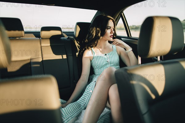 Caucasian woman sitting in back seat of car