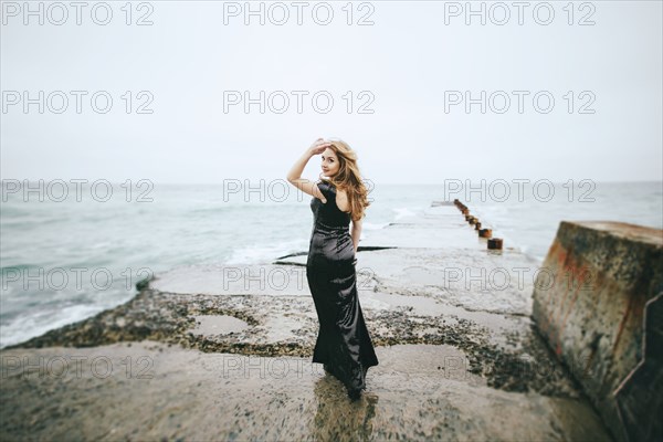 Portrait of smiling Caucasian woman wearing dress near ocean