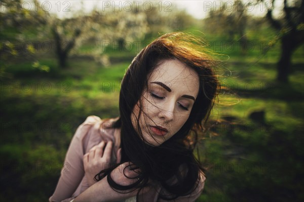 Wind blowing hair of pensive Caucasian woman