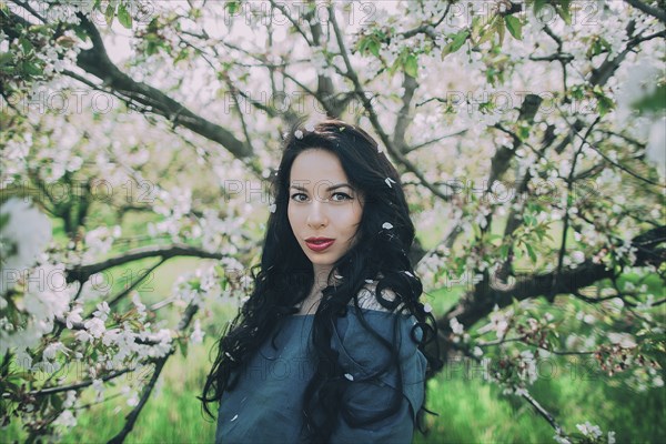 Caucasian woman posing near flowering tree