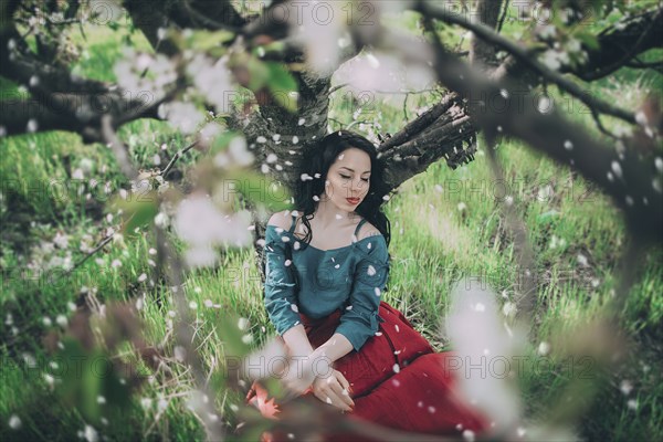 Petals falling from flowering tree on Caucasian woman