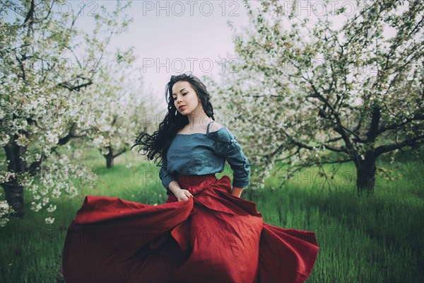 Caucasian woman dancing near flowering trees